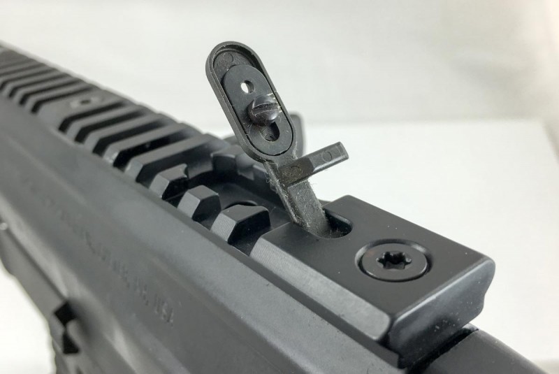 A pop-up rear sight is embedded into the receiver rail.