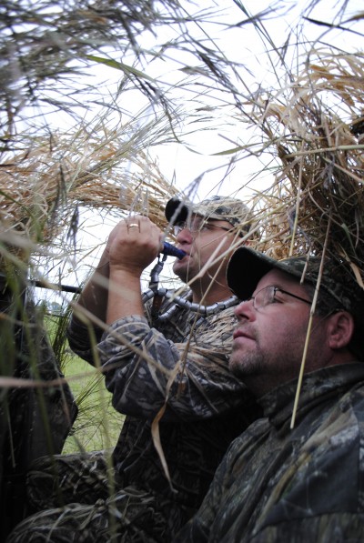 Joe Robison call geese from a blind while Ron Levitan watches for them.