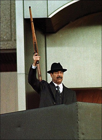 Saddam Hussein carries his Ruger M77 in one of the most well-known images of the Iraqi dictator.