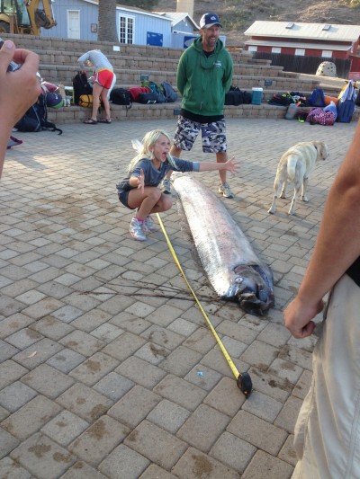 A CIMI student poses with the large oarfish.