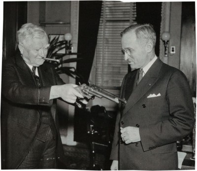 John Nance Garner (left) shows the James revolver and another firearm to Harry Truman. 