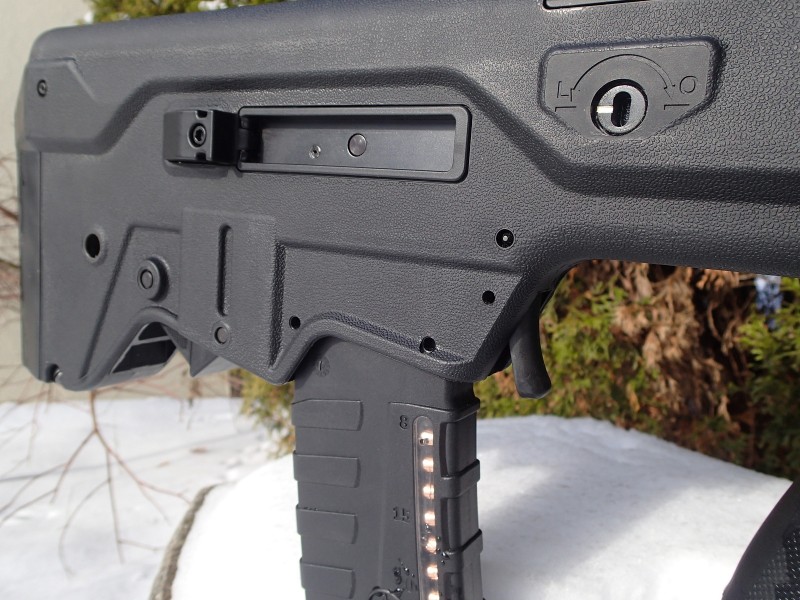 Some of the Tavor's controls are fully ambidextrous. Seen  here are the magazine release "trigger" (located just in front of the magazine) and the bolt release (which can be seen just barely peeking out behind the magazine). Note also the two locking pins for the trigger mechanism.