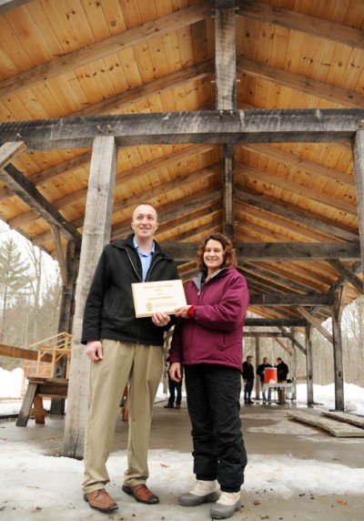 Stephen Hadfield, a tech-ed teacher at Pittsville High School in Wood County, receives a 2013 Wisconsin School Forest Award from the DNR’s Gretchen Marshall for directing construction of this timber-frame shelter at the Pittsville School Forest.