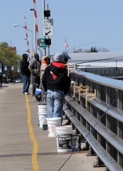 Fishermen on the Winneconne bridge must keep themselves and their gear inside the yellow line on the bridge’s north sidewalk. Image by Patrick Durkin.