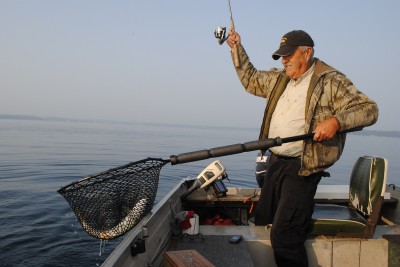 Al Scott nets a lake trout jigged out of deep water.