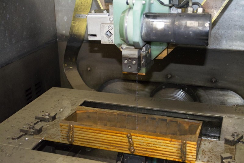 The wire EDM machine uses a fine jet of water to guide a very thin wire through the material to be cut.