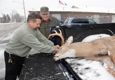 Lee Simonar, left, owner of Lee’s Sports in Luxemburg, registers a buck arrowed November 9 by local bowhunter Dana Lemens.