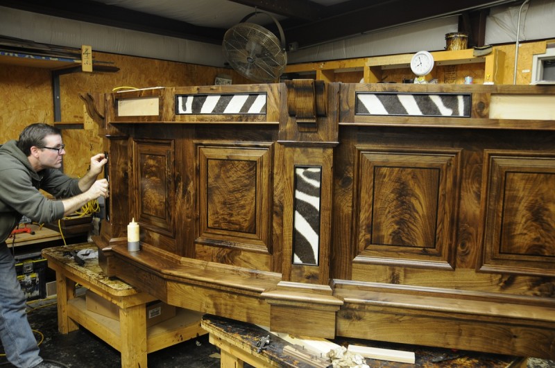 A craftsman at Julian & Sons builds a custom bar for a client trophy room.