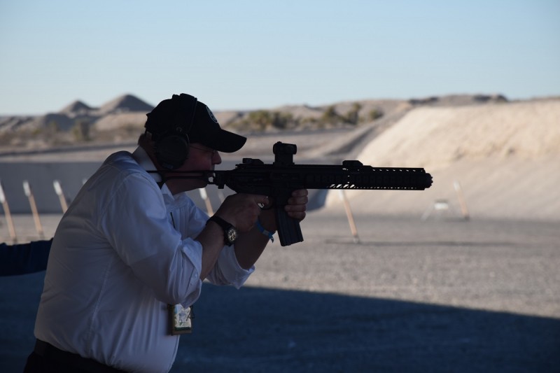 A shooter with an MCX equipped with an extended handguard and suppressor.