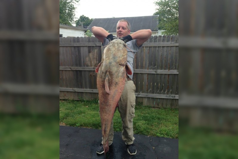 James Klauzer hoisting his 81.4-pound flathead catfish.