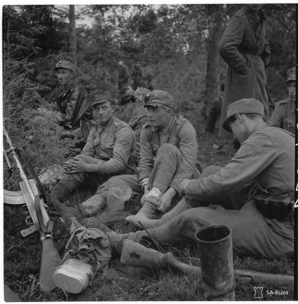 Finnish soldiers taking a break during a march. An M/26 can be seen on the left, while an M/39 Mosin-Nagant lays upside down nearby. Date taken: Jun 25, 1944.