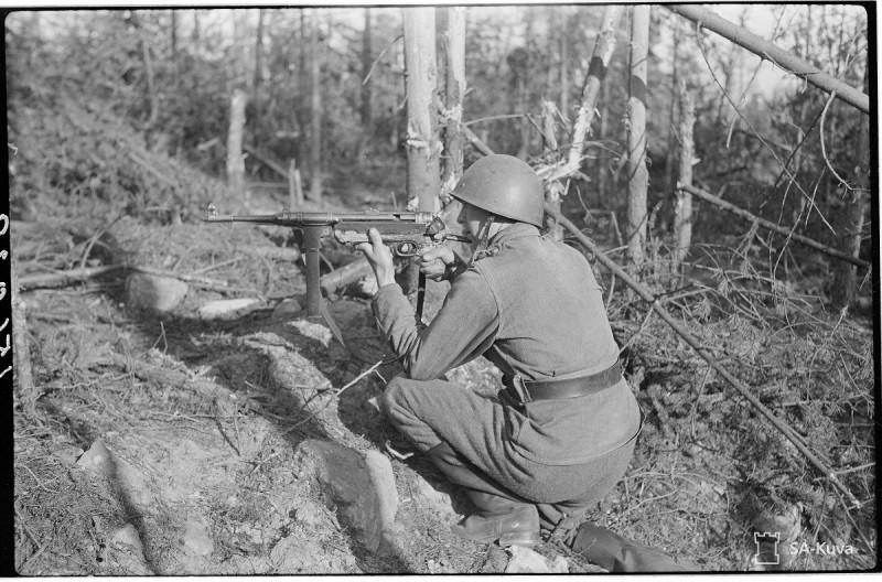 A Finnish soldier aims a German MP-40 submachine gun. Date taken: July 13, 1944.