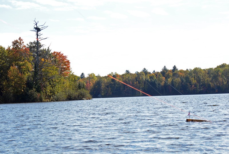 A trolling ski slices the water while towing muskie lures near a bald eagle’s nest.