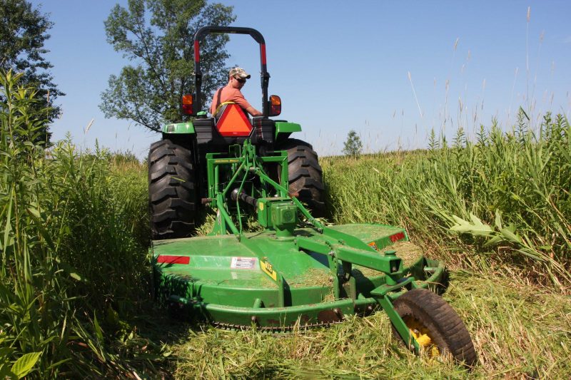 A rotary cutter takes tall grasses and other plants down to size.
